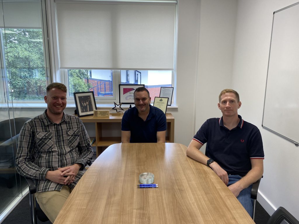 Three ex armed forces servicemen sitting around desk at Risk Evolves office